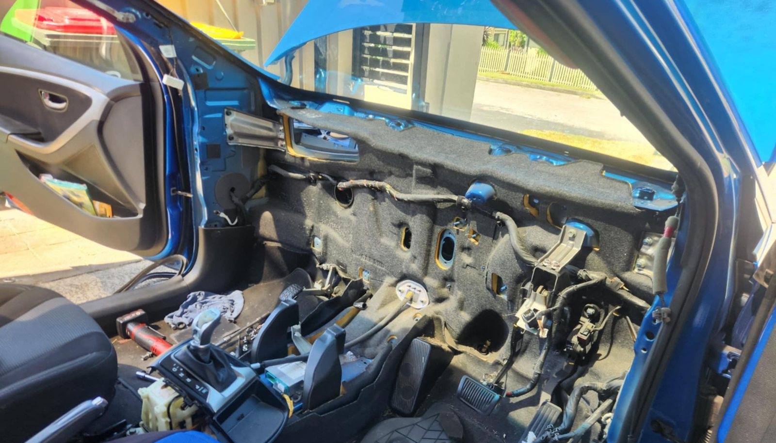 A car interior with the dashboard removed for evaporator work